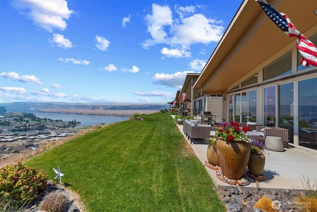 view of yard with a water view and a patio area