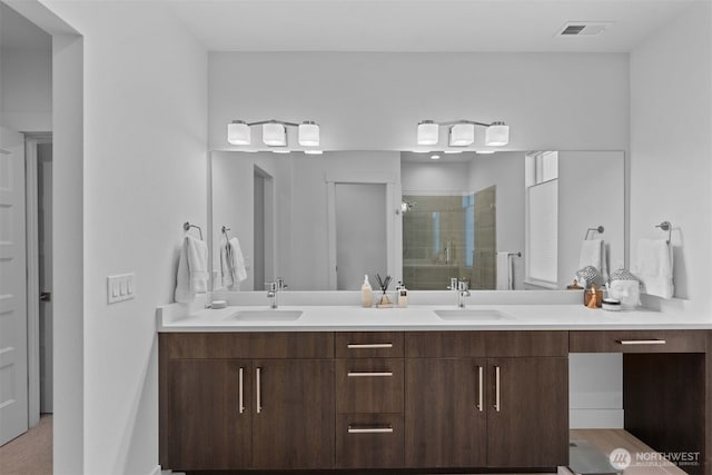 full bathroom featuring a sink, visible vents, a shower stall, and double vanity