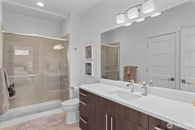 full bathroom with a shower stall, tile patterned floors, vanity, and toilet