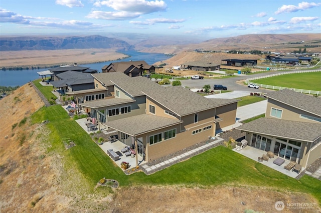 drone / aerial view featuring a water and mountain view and a residential view