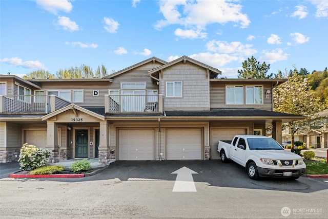 multi unit property featuring driveway, a balcony, and a garage