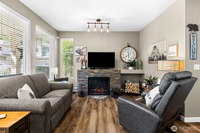 living room featuring a fireplace, baseboards, a baseboard heating unit, and dark wood-style floors