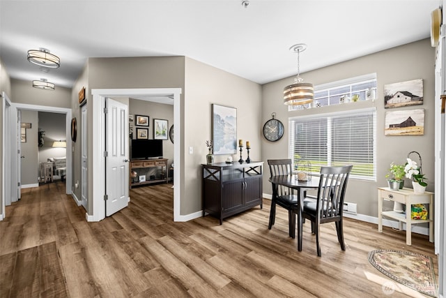 dining area featuring light wood-type flooring and baseboards