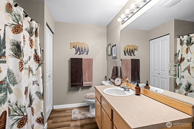 full bathroom with wood finished floors, vanity, toilet, and baseboards