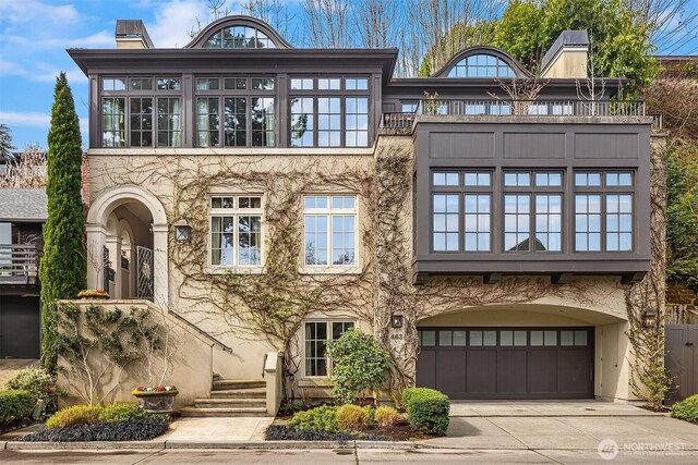 463 39th Ave E, Seattle, WA 98112 - view of front of home featuring stucco siding, driveway, and a garage