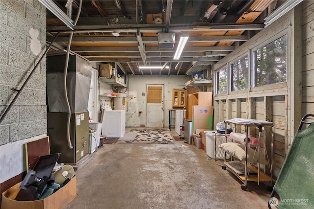 basement featuring heating unit, secured water heater, and washer / clothes dryer