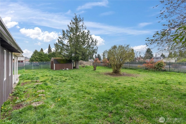 view of yard featuring a fenced backyard, an outdoor structure, and a storage shed
