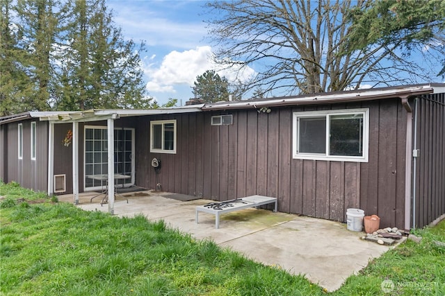 back of property featuring board and batten siding and a patio area