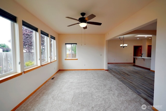230 Choice Loop, Sequim, WA 98382 - spare room featuring ceiling fan, a chandelier, carpet floors, wood finished floors, and arched walkways