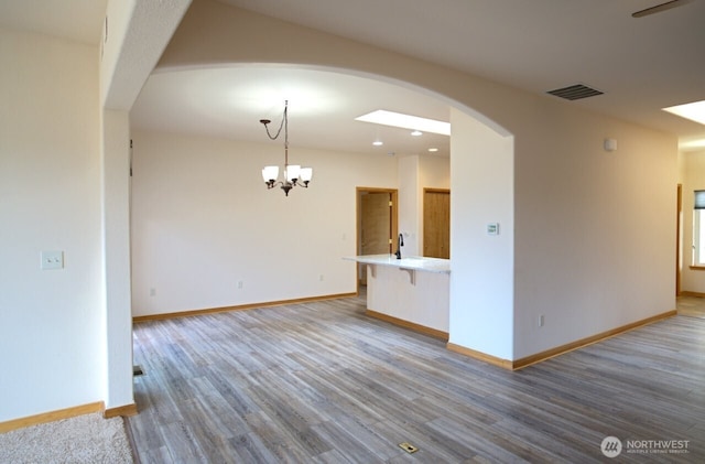 230 Choice Loop, Sequim, WA 98382 - unfurnished living room with arched walkways, wood finished floors, a chandelier, and recessed lighting