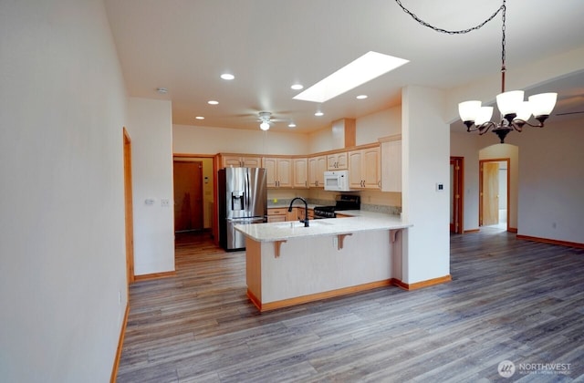 230 Choice Loop, Sequim, WA 98382 - kitchen with stainless steel fridge, black gas range, white microwave, a peninsula, and wood finished floors