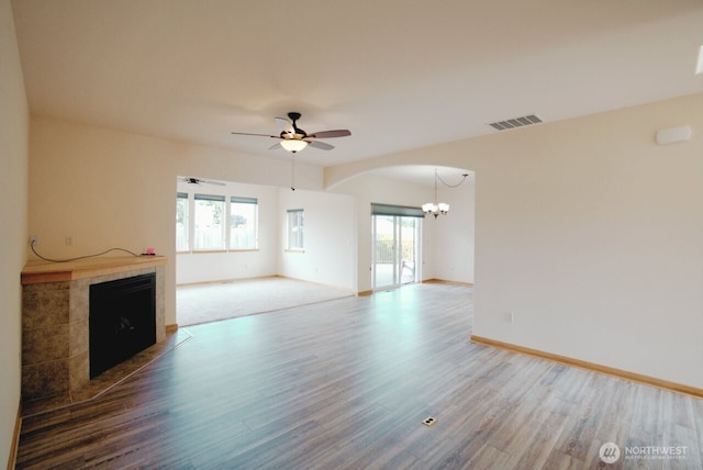 230 Choice Loop, Sequim, WA 98382 - unfurnished living room featuring a tiled fireplace, wood finished floors, healthy amount of natural light, and a chandelier
