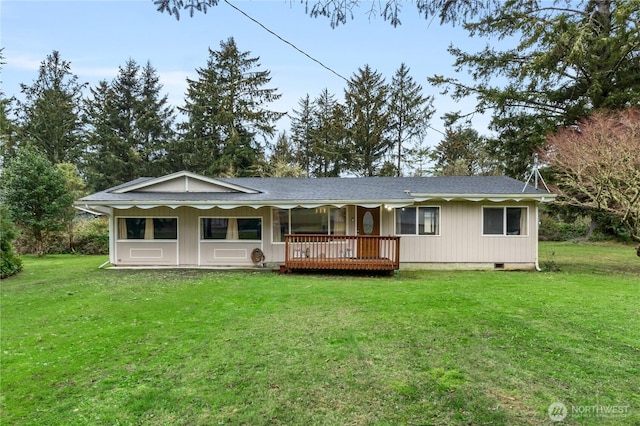 rear view of house with a lawn, a shingled roof, and crawl space