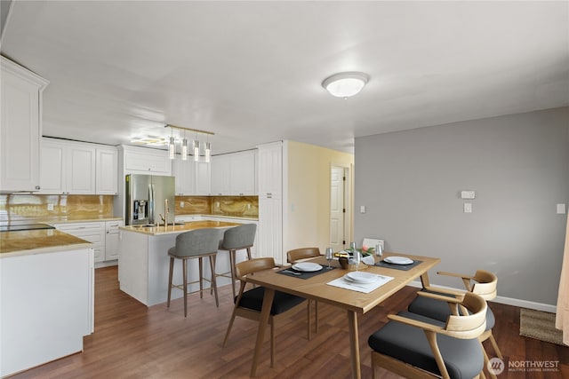dining room with dark wood-type flooring and baseboards