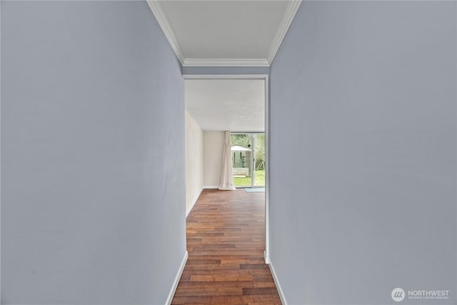 corridor featuring ornamental molding, baseboards, and wood finished floors