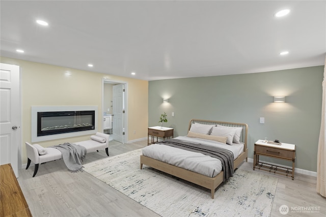 bedroom featuring baseboards, a glass covered fireplace, recessed lighting, and light wood finished floors