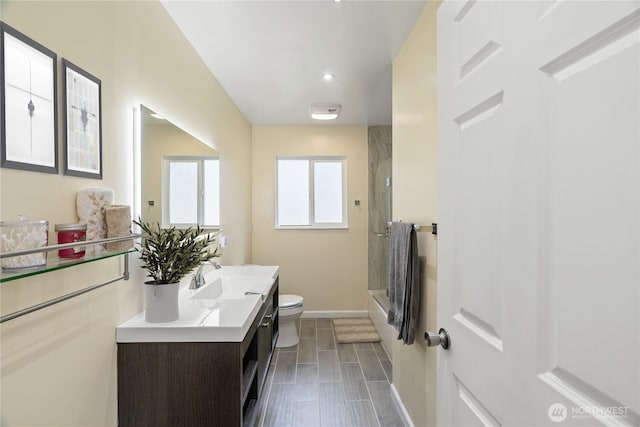 bathroom with baseboards, shower / tub combination, toilet, and vanity