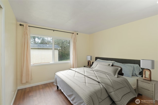 bedroom with baseboards and wood finished floors