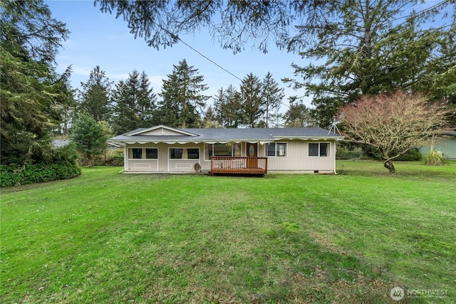 rear view of house with a lawn, a deck, and crawl space