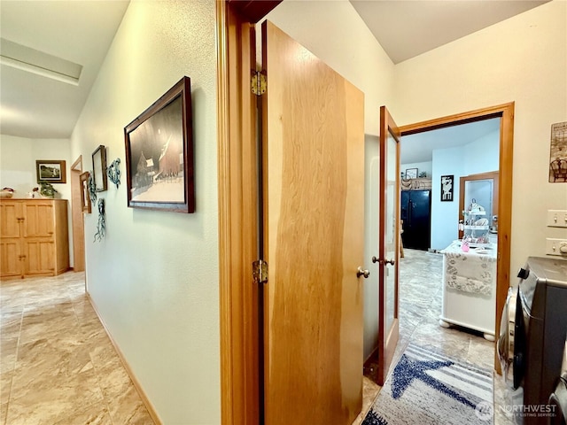 hall featuring baseboards and stone finish flooring
