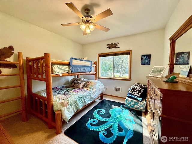 carpeted bedroom with baseboards, visible vents, and a ceiling fan