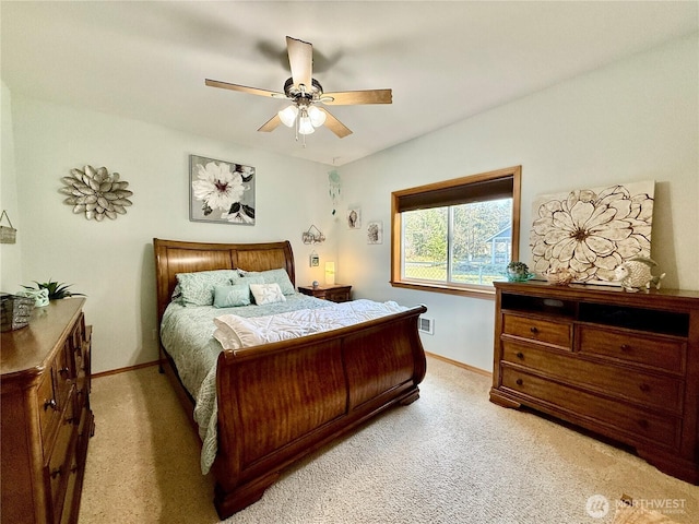 bedroom featuring baseboards, visible vents, a ceiling fan, and light colored carpet
