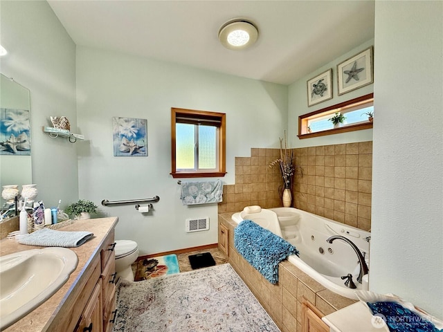 bathroom with a wealth of natural light, a whirlpool tub, vanity, and baseboards