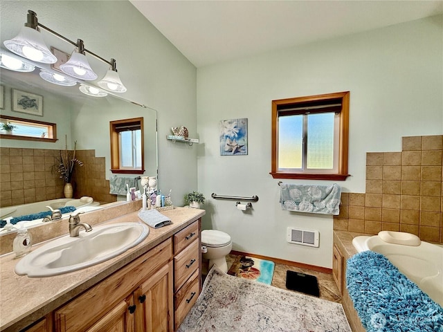 full bath featuring tile patterned flooring, vanity, tile walls, toilet, and a bath
