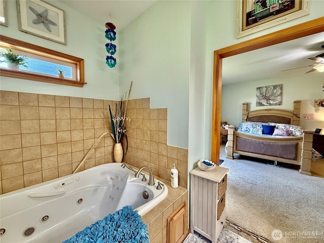 ensuite bathroom with ensuite bathroom, a jetted tub, and a ceiling fan