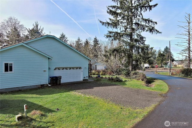 view of side of property with driveway and a yard