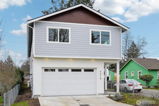 view of front facade with fence, driveway, and a garage