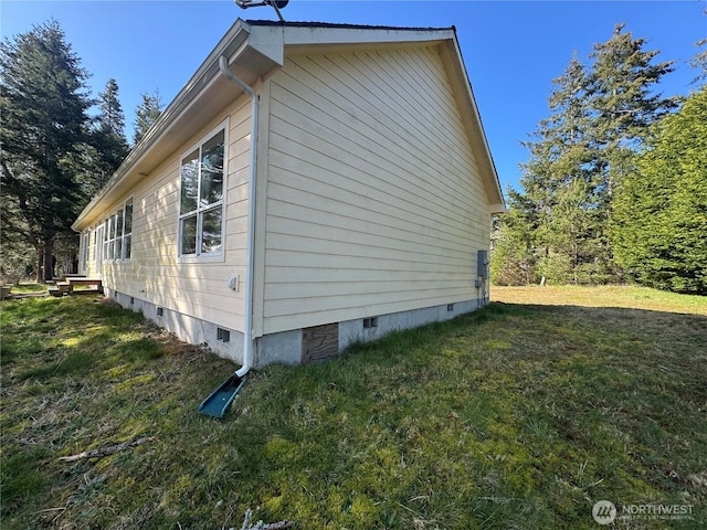 view of side of home featuring crawl space and a yard