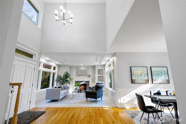 17955 SE 60th St, Bellevue, WA 98006 - living area featuring a wainscoted wall, light wood finished floors, a high end fireplace, a decorative wall, and a notable chandelier