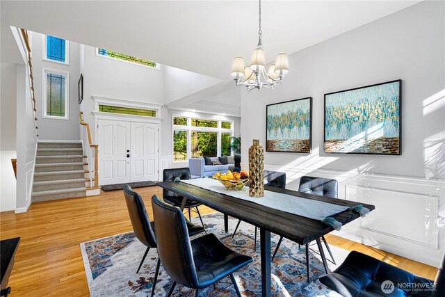17955 SE 60th St, Bellevue, WA 98006 - dining space with a wainscoted wall, a notable chandelier, stairs, and light wood-type flooring