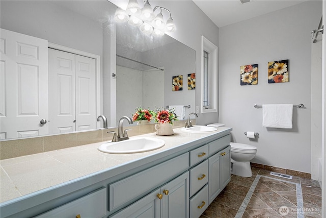 17955 SE 60th St, Bellevue, WA 98006 - bathroom featuring baseboards, visible vents, double vanity, and a sink