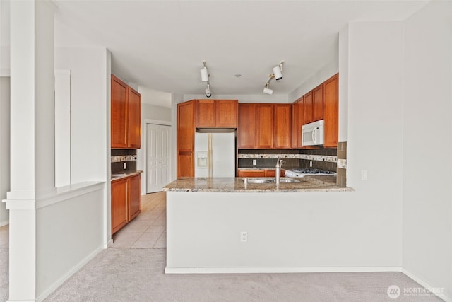 109 2nd St S Unit 337, Kirkland, WA 98033 - kitchen featuring white appliances, a peninsula, decorative backsplash, light colored carpet, and a sink