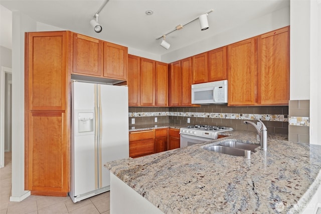 109 2nd St S Unit 337, Kirkland, WA 98033 - kitchen featuring a sink, white appliances, a peninsula, brown cabinetry, and light stone counters