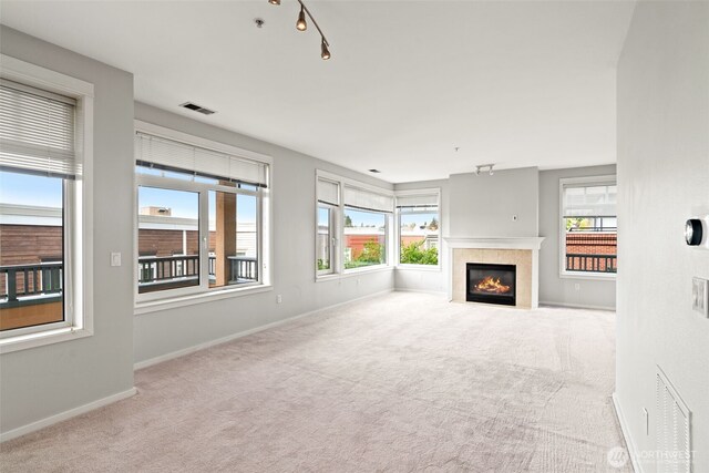 109 2nd St S Unit 337, Kirkland, WA 98033 - unfurnished living room with visible vents, baseboards, a tile fireplace, and carpet floors