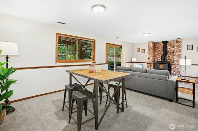 3429 167th Ave SE, Bellevue, WA 98008 - dining area featuring light colored carpet, a wood stove, and baseboards