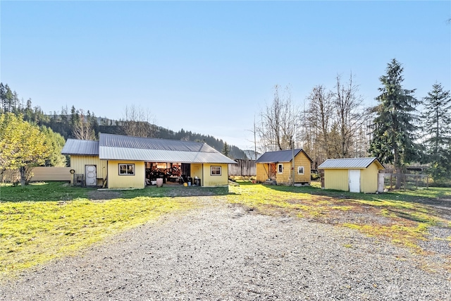 192 Meade Hill Rd, Glenoma, WA 98336 - single story home with an outbuilding, fence, an outdoor structure, metal roof, and gravel driveway