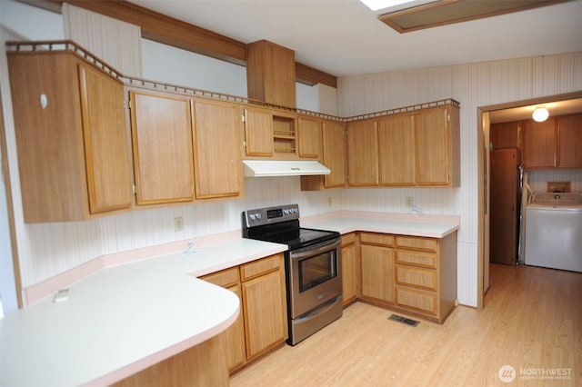 1415 84th St SE Unit 136, Everett, WA 98208 - kitchen featuring light wood-style flooring, under cabinet range hood, washer / dryer, visible vents, and stainless steel electric stove