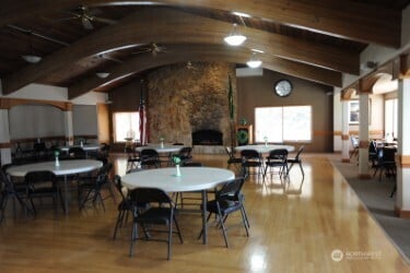 1415 84th St SE Unit 136, Everett, WA 98208 - dining area featuring lofted ceiling with beams, wood finished floors, a fireplace, and a healthy amount of sunlight