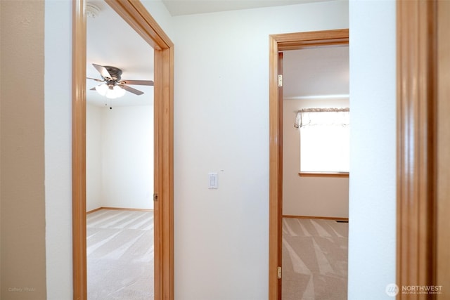 hall with baseboards and carpet