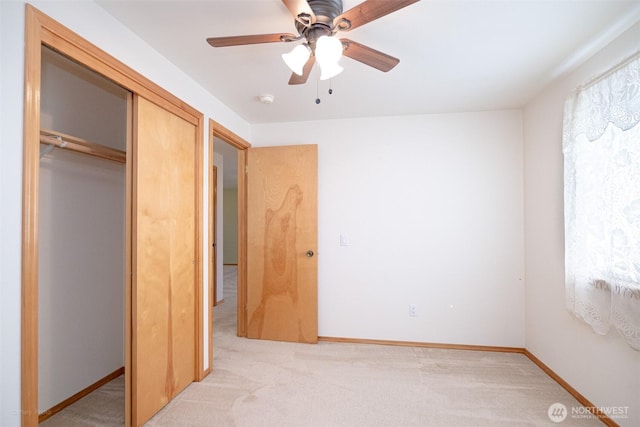 unfurnished bedroom featuring light carpet, baseboards, and a closet