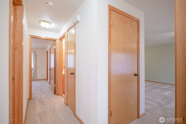 corridor with light carpet and baseboards