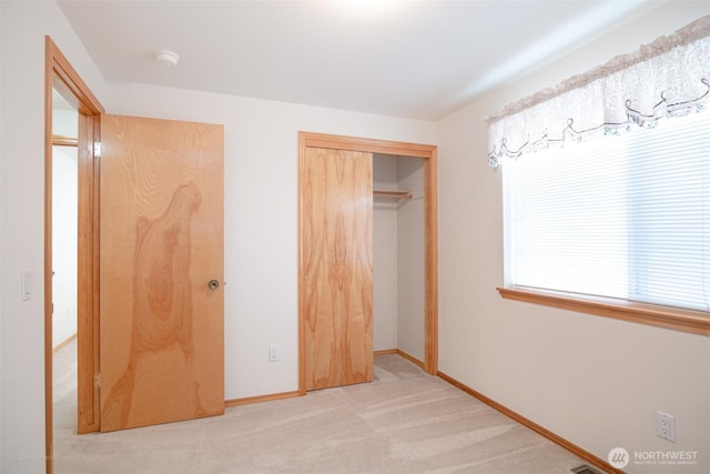 unfurnished bedroom with a closet, baseboards, and carpet flooring