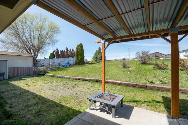 view of yard featuring a patio area, fence, an outdoor structure, and a storage unit