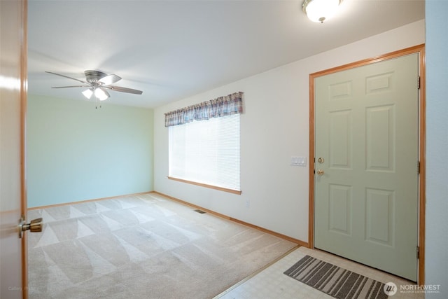 entryway featuring light colored carpet, baseboards, a ceiling fan, and visible vents