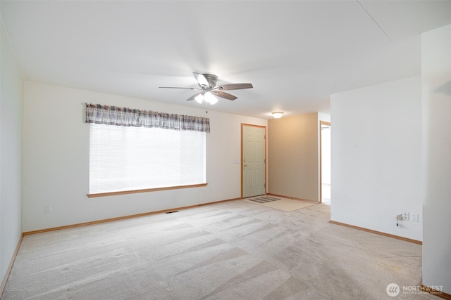 empty room with baseboards, a ceiling fan, and carpet floors