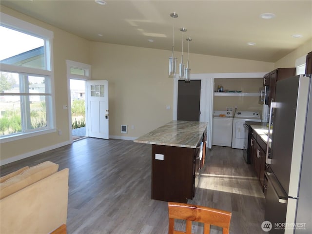 943 Silver King Ave SE, Ocean Shores, WA 98569 - kitchen featuring freestanding refrigerator, separate washer and dryer, dark brown cabinetry, a center island, and vaulted ceiling